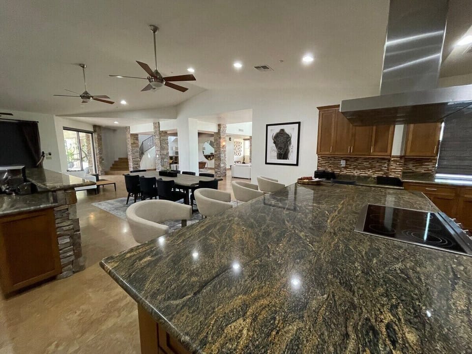 Spacious kitchen with granite slab countertops and stainless steel appliances.
