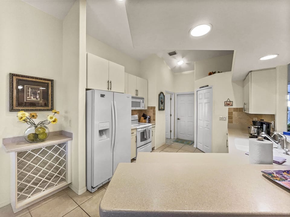 Kitchen with white cabinets, wine rack, and full-size refrigerator