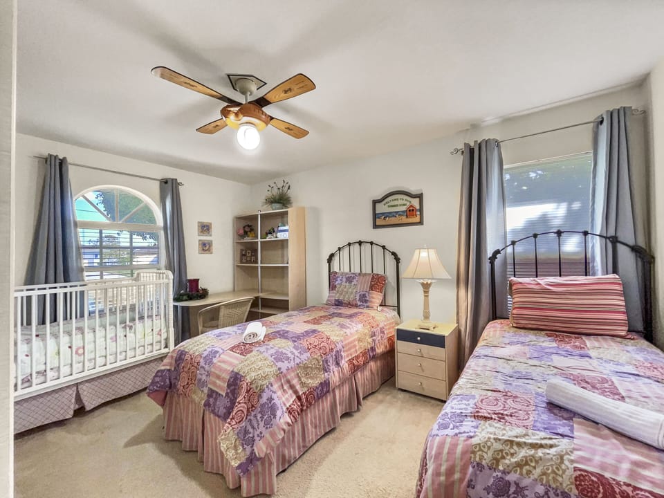 Flexible bedroom with crib and twin beds, suitable as a nursery or extra sleeping space