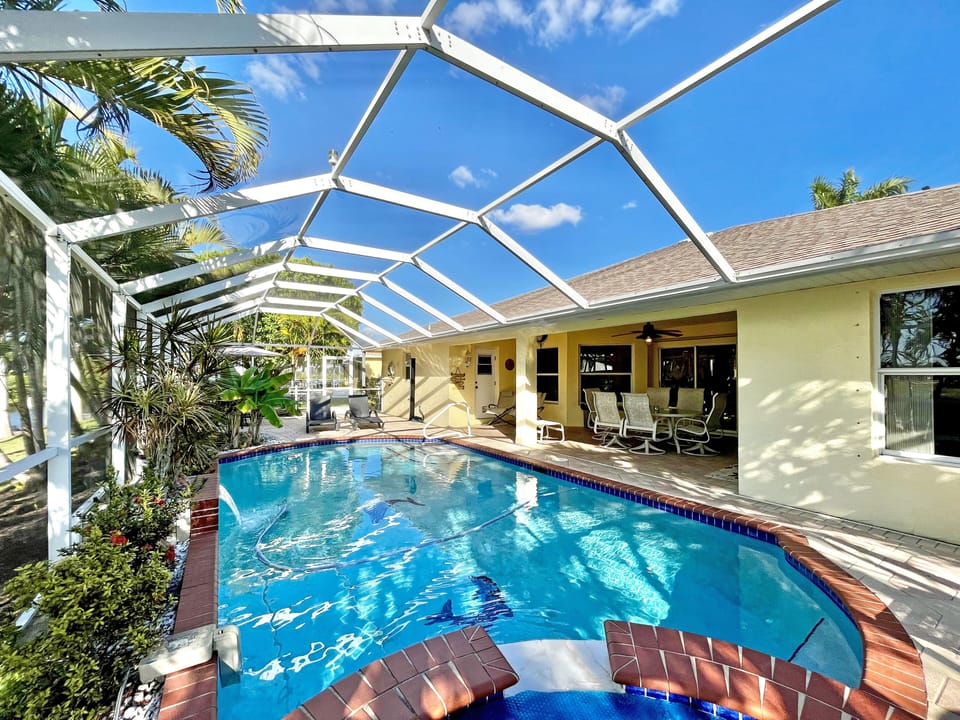 Pool and screened enclosure with the home exterior visible in the background