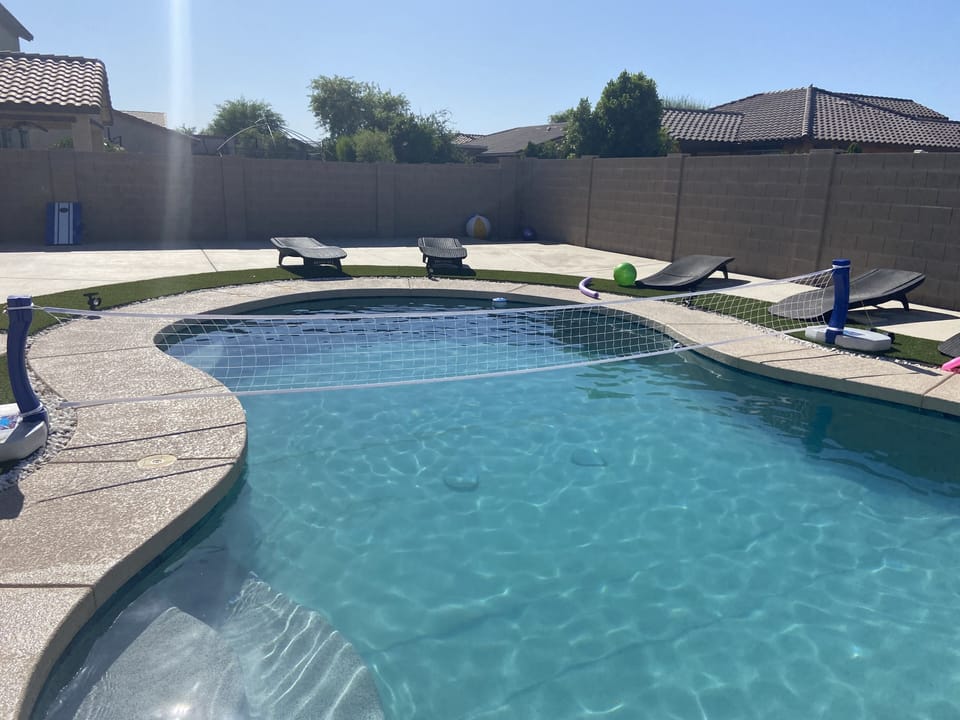 Pool with lawn chairs and large umbrellas to protect from sun 