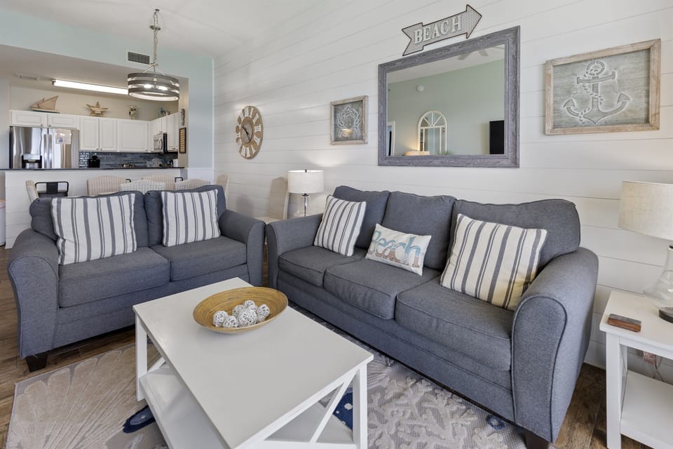 Sink into coastal comfort on plush gray sofas surrounded by charming nautical touches and beachy décor.
