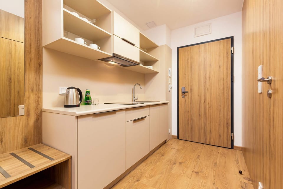 Functionally equipped kitchenette in the living area of the studio with a kettle and fridge.