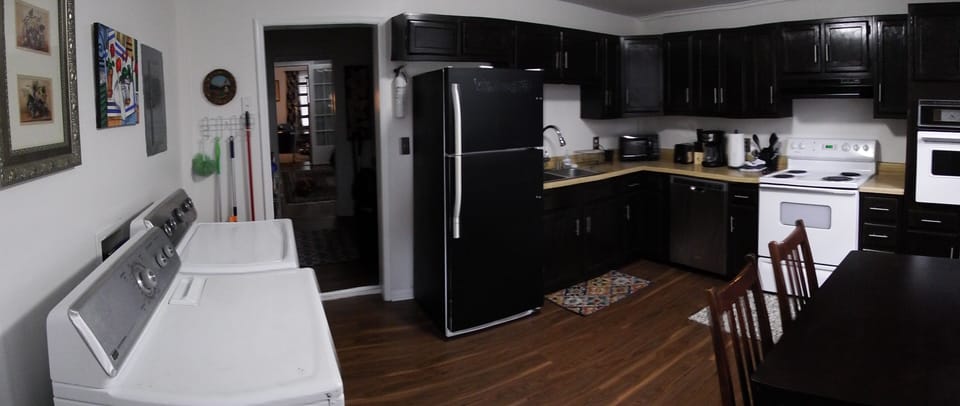Well stocked kitchen with small dining table, laundry, coffee pot, microwave...