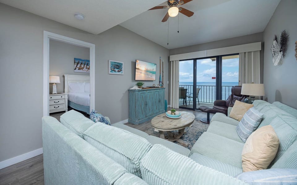 Bright and inviting living area with a cozy sofa with queen sleeper, beachfront balcony, and stylish decor