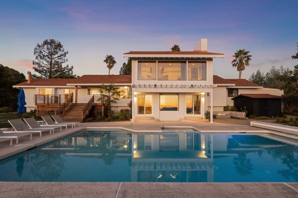 Saltwater pool that is gas heated all year, 8 pool loungers, fire pit with outdoor sectional couch, large view deck, and outdoor dining.