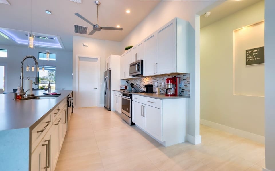 Gourmet kitchen with stainless steel refrigerator, microwave, and modern cabinetry with quartz countertops