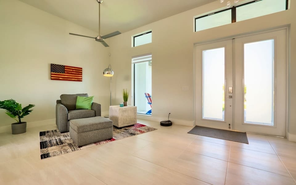Bonus sitting room with a sofa, high ceilings, large windows, and patriotic wall art
