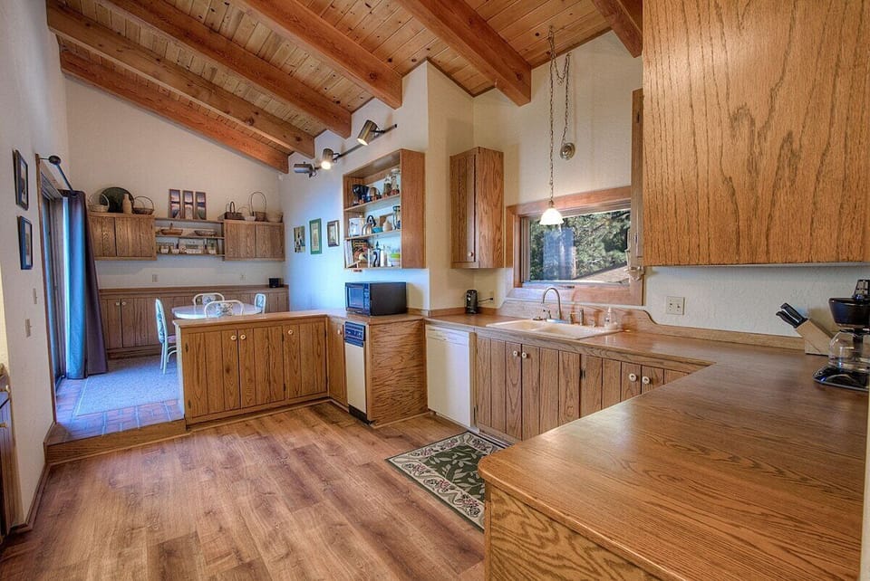 Another look at the kitchen, with sliding door, dining table, dining chairs, and counters.
