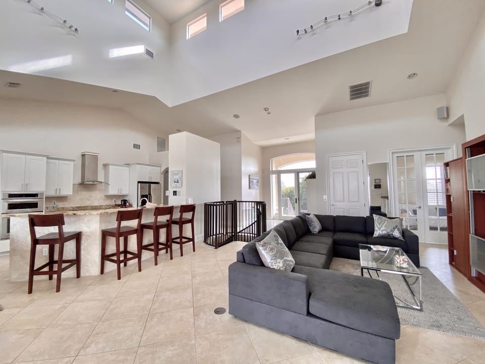 Lounge with TV and large comfortable sectional sofa open plan to kitchen 