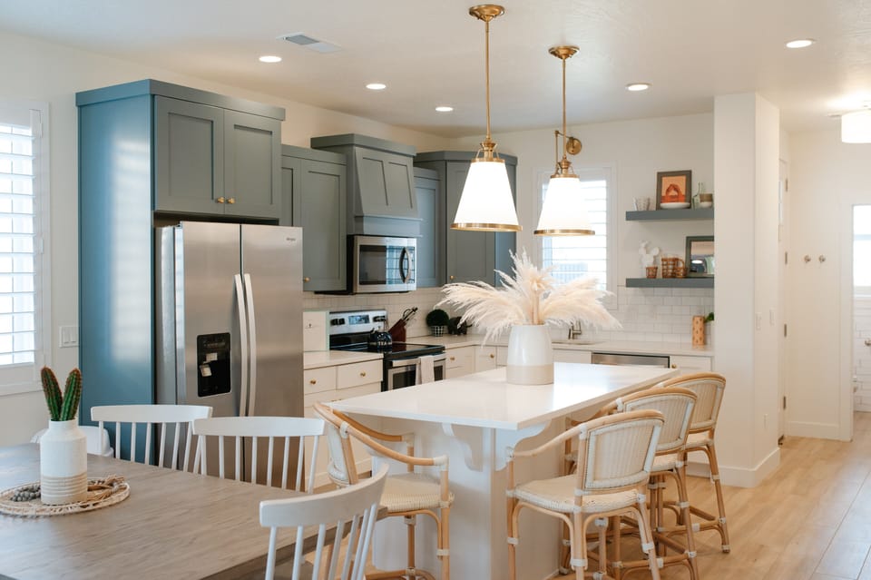 Cook and connect in the modern kitchen with stainless steel appliances, large island seating, and open layout — ideal for family stays near St. George.