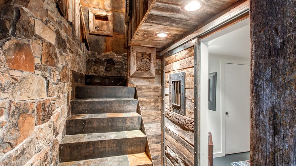 Unique rustic staircase and entryway with authentic reclaimed wood and stone. A charming, historic feel guides you to your mountain retreat.