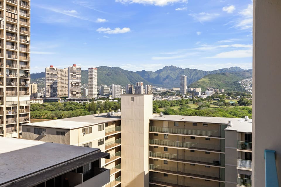 Panoramic cityscape with mountains in the distance creates a stunning backdrop for the urban surroundings.