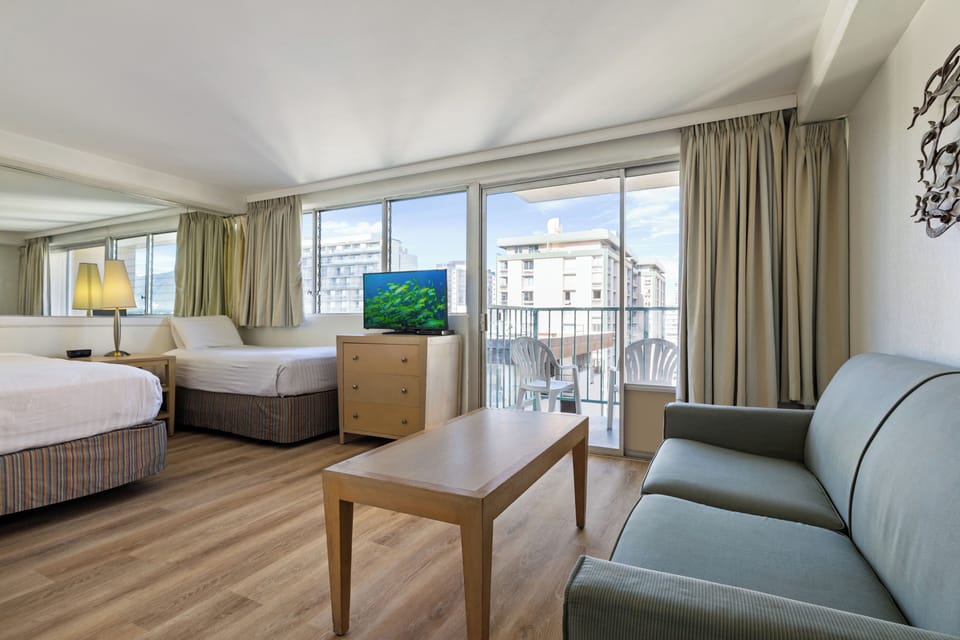 Relax in your spacious room with city views from your private balcony, complete with comfortable seating and modern amenities for the perfect getaway.