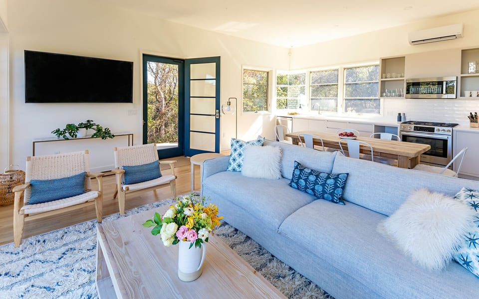 An open concept layout with a high ceiling and lots of windows, natural light.