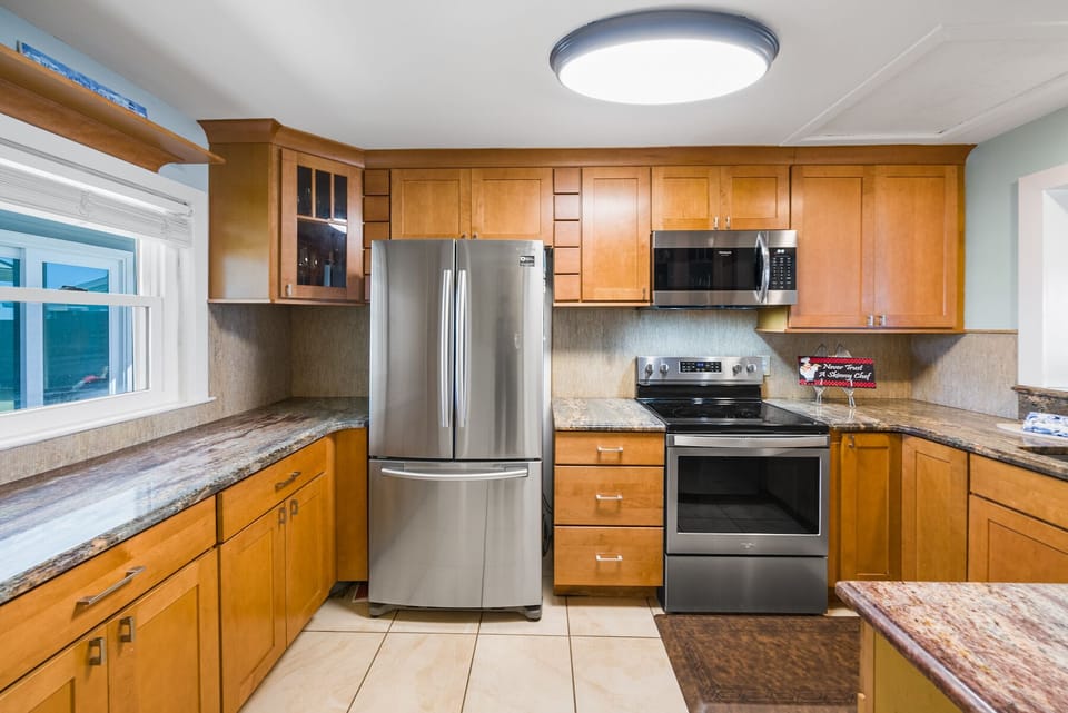 Your fully equipped kitchen features warm wood cabinets, granite countertops, and stainless steel appliances for memorable home-cooked meals.