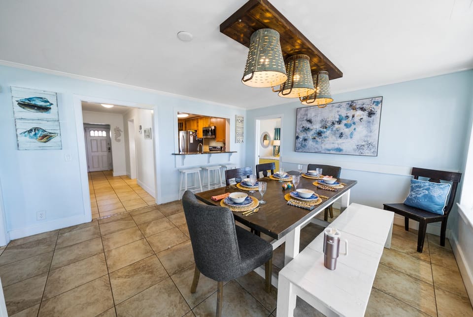 Gather around your elegant dining table, where coastal charm meets modern comfort under unique woven pendant lights.