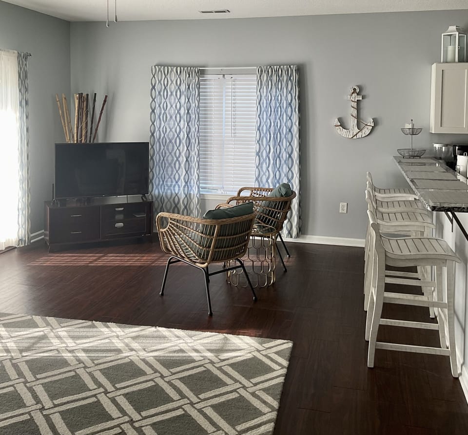 open concept den with big TV and additional seating. 