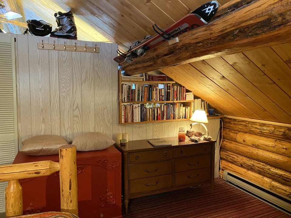 Thin/partial wall & door dividing upstairs bedrooms, complete with a bookshelf!