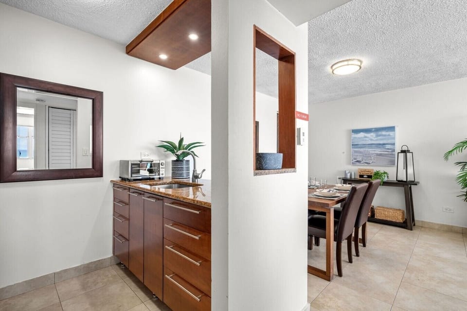 Open living and dining space with beach views, natural light, and a fully equipped kitchen