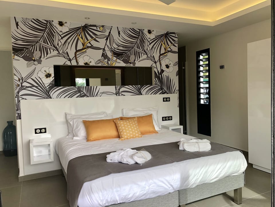 Villa Chuty : large lit confortable et salle de bains semi ouverte.