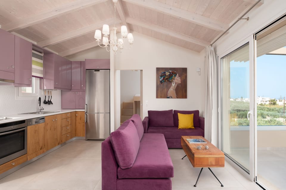 The First floor living room & kitchen with a balcony filled with sea views.