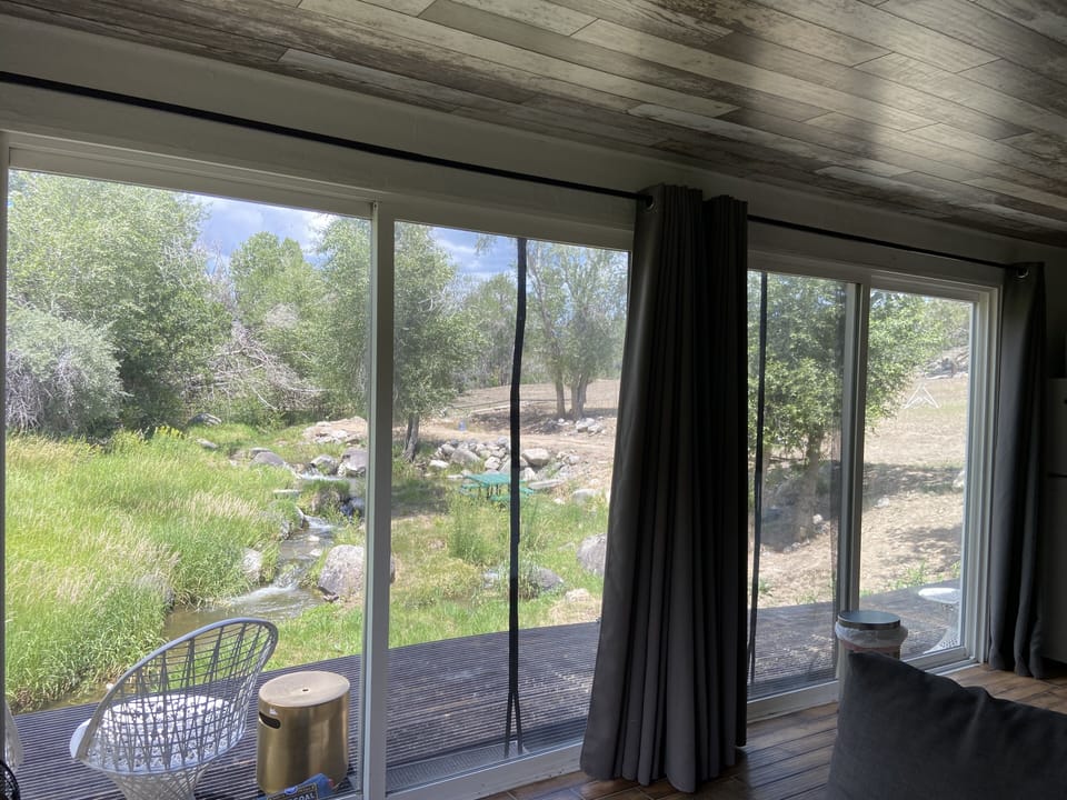 living room kitchen views looking north over deck and creek