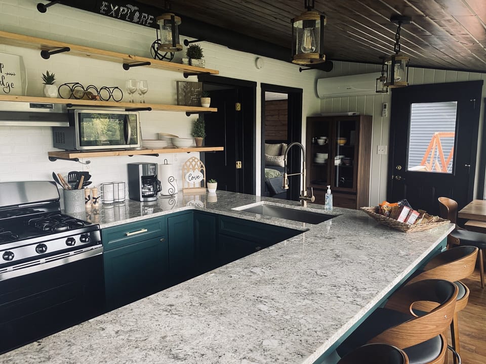 Full Kitchen with Microwave, gas stove, refrigerator, bar and built in nook.