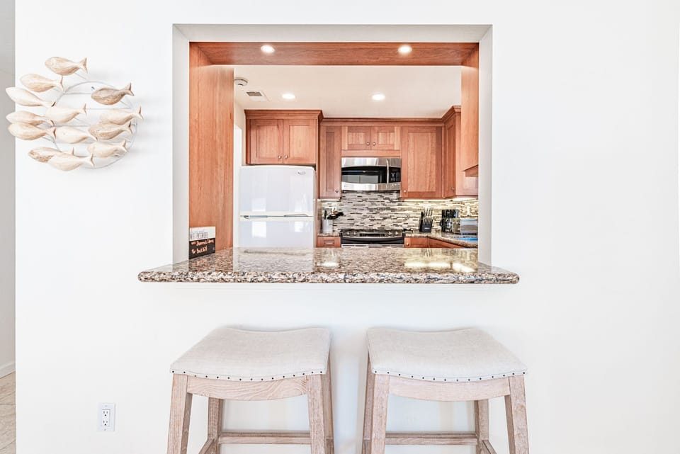 Breakfast bar with stools peers into the kitchen.
                