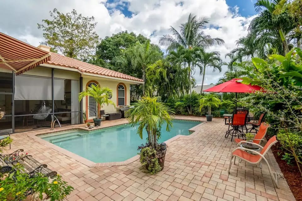 Salt water pool and fenced property with plenty of palms and bushes for privacy