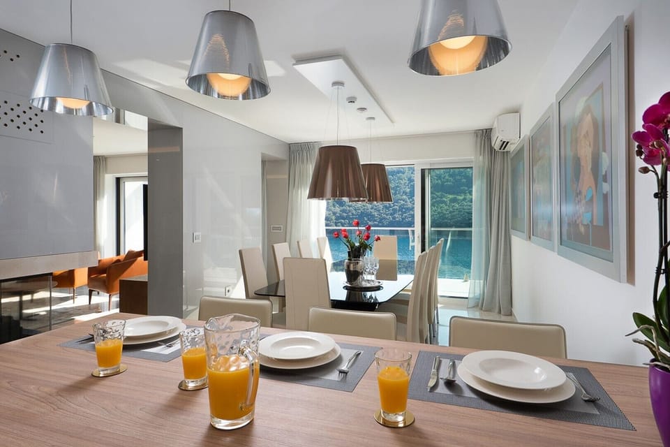 Modern fully-equipped kitchen with wooden dining table of Labin Luxury Villa Palace with private pool, jacuzzi and gym.