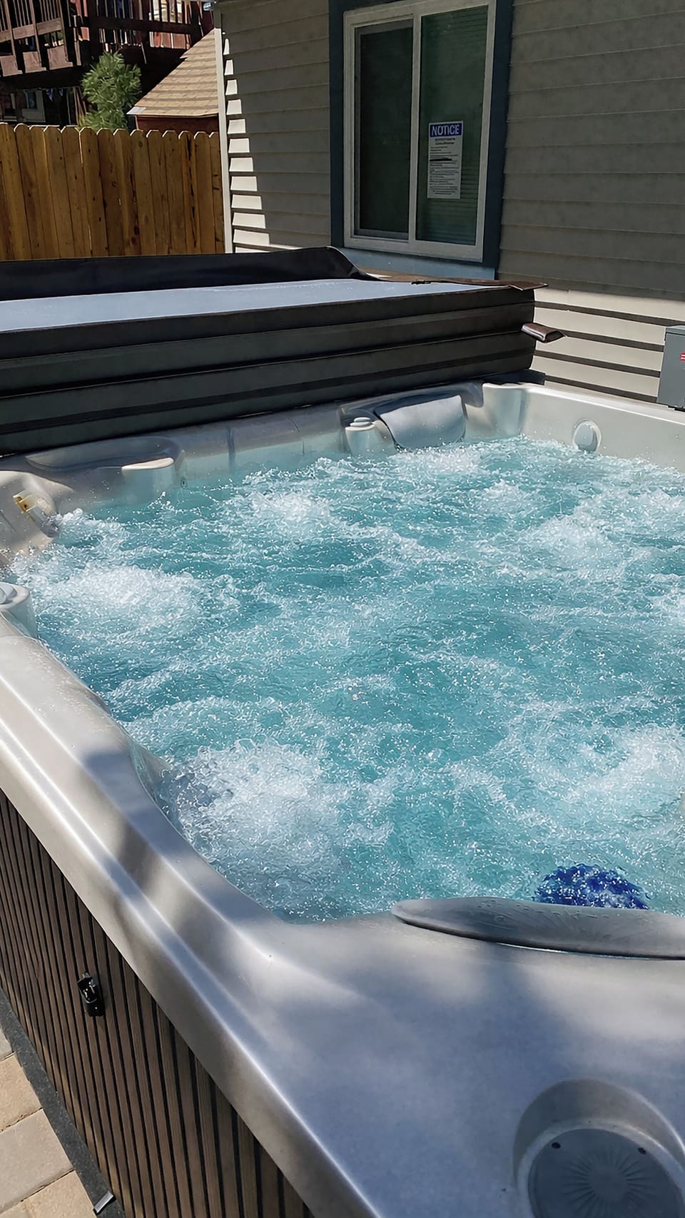 Private jetted hot tub on sunny patio—perfect for relaxing soaks.