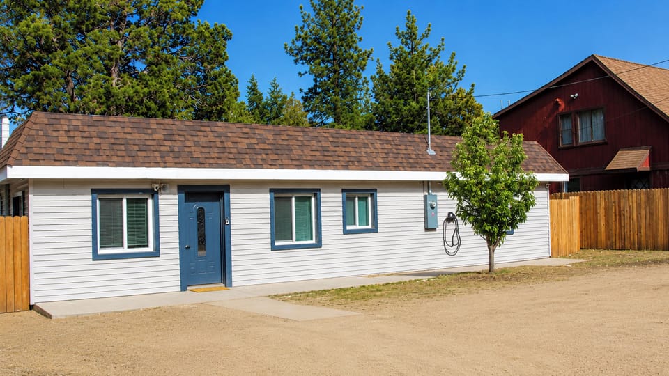 Cozy standalone cottage with fenced yard, trees, and easy parking