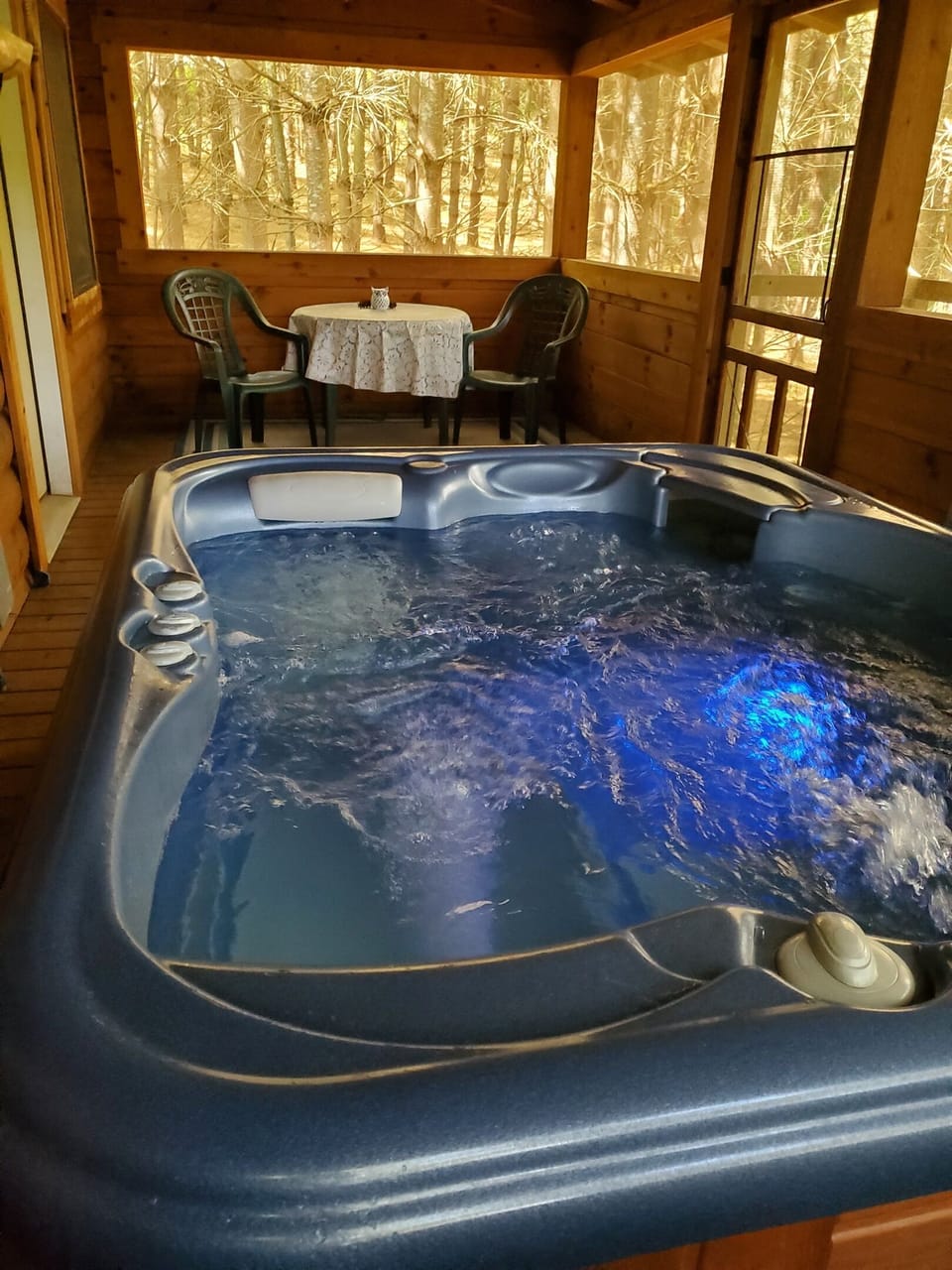 Secluded on the screened cedar porch, the hot tub offers a private oasis for soothing soaks amidst the serene sounds of the forest.