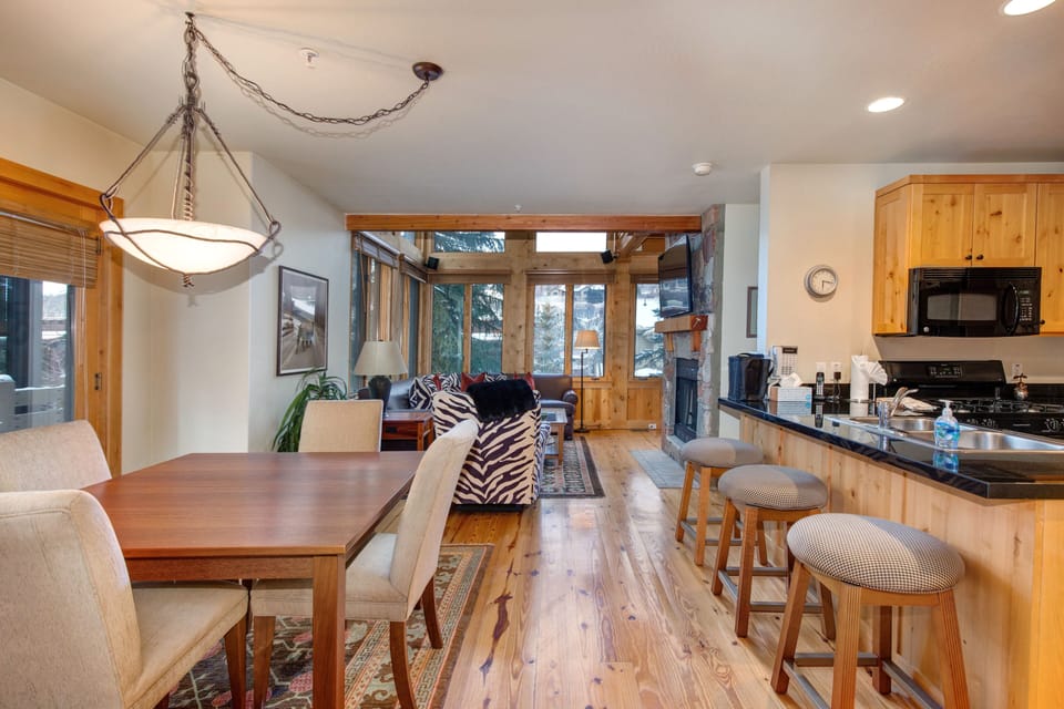 Living Room with vaulted ceilings, stunning windows that allow for an abundance of natural light, leather furnishings, full sofa-bed, gas fireplace, and 55" Vizio TV