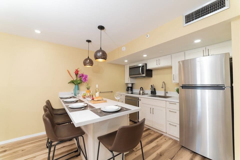 Modern kitchen with island seating, stainless appliances, and pendant lights adding a stylish glow.