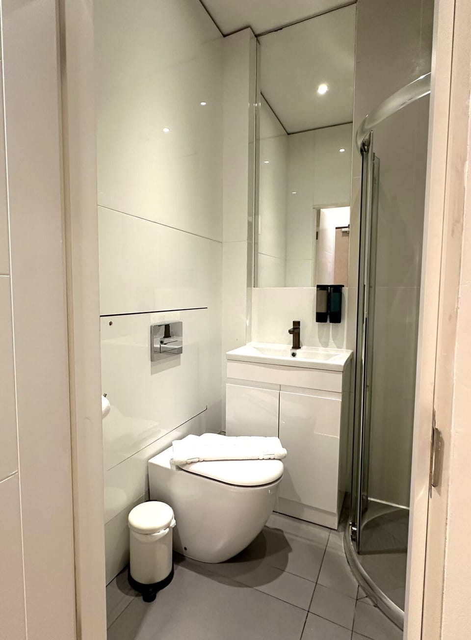 A standard toilet with shower, shampoo, conditioner, and toiletries.