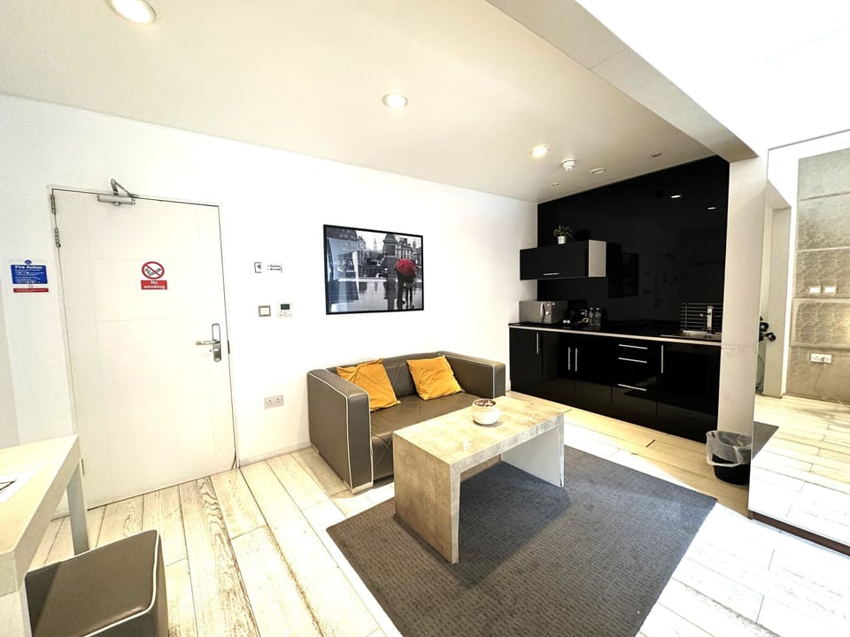 Kitchen equipped with microwave, coffee and tea kettle, mini fridge, and private space.