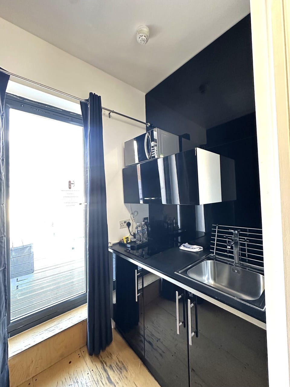 Kitchen equipped with microwave, coffee and tea kettle, mini fridge, and private space.