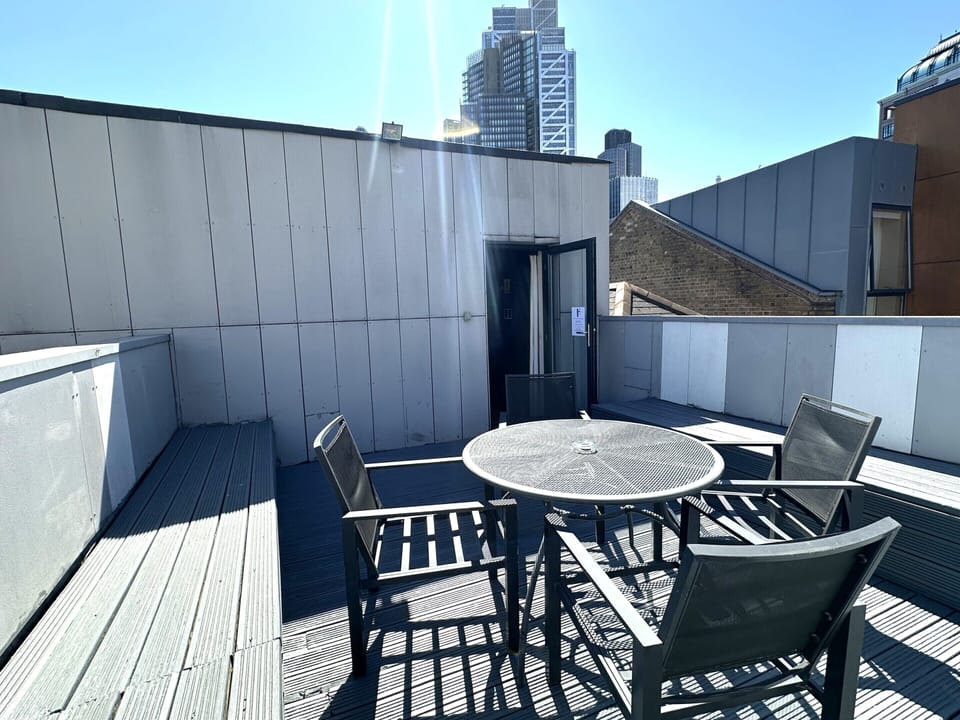 Spacious terrace with seating area and stunning city views from the top floor