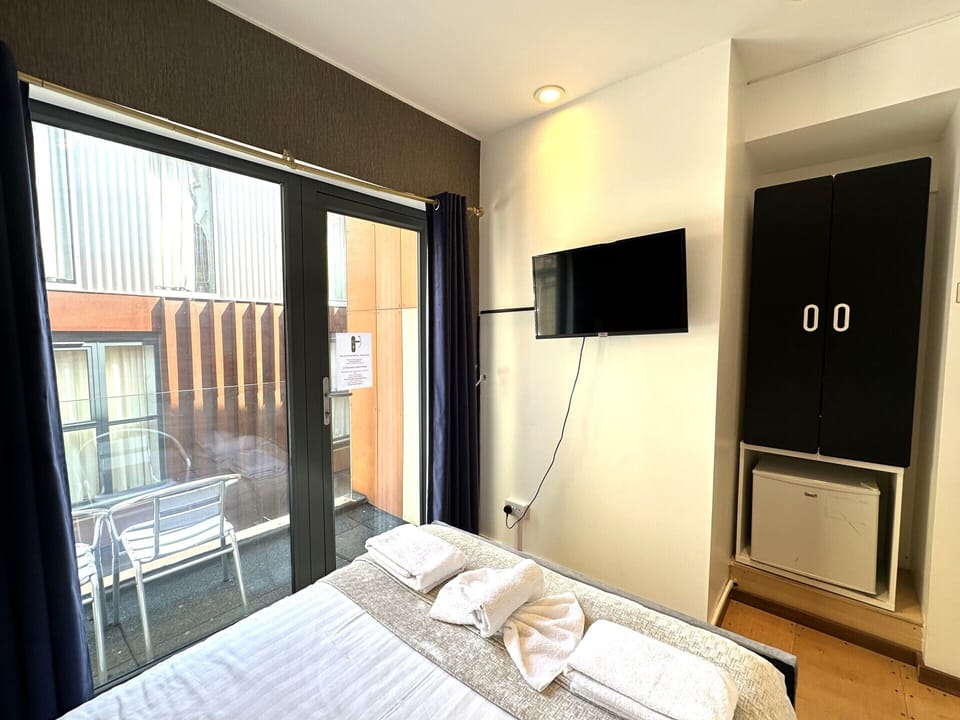 Comfortable double room featuring a private bathroom, a cosy small balcony, and a spacious double bed for a restful stay.