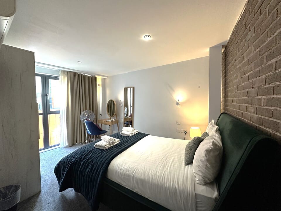 Comfortable spacious studio for two guests featuring a kitchenette, private bathroom, double bed, and cleanliness.