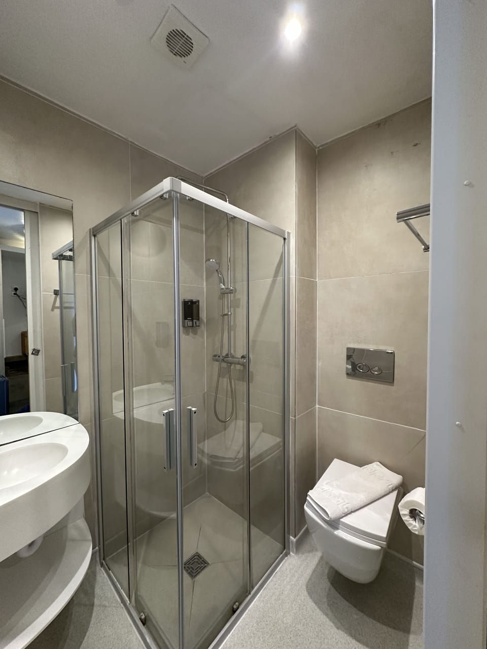 A standard bathroom with a shower, hand wash, shampoo, conditioner, clean toilet, toilet paper and more. 