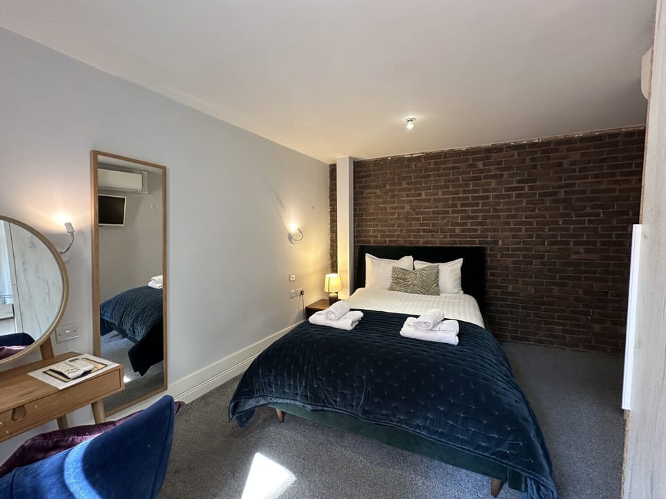 Comfortable spacious studio for two guests featuring a kitchenette, private bathroom, double bed, and cleanliness.