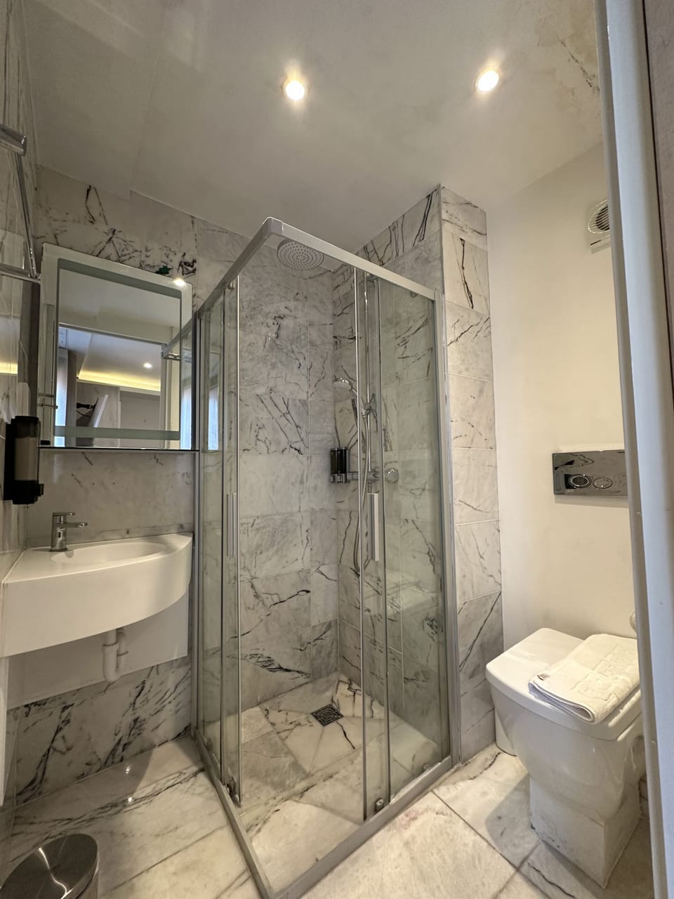A standard bathroom with a shower, hand wash, shampoo, conditioner, clean toilet, toilet paper and more. 