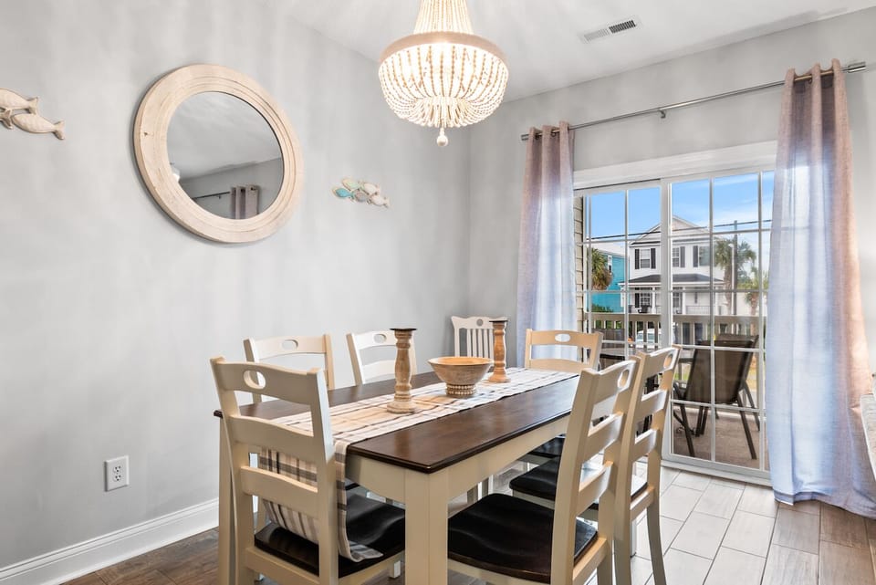 Gather your group around this welcoming dining table, where meals become memories under the soft glow of a stunning chandelier.