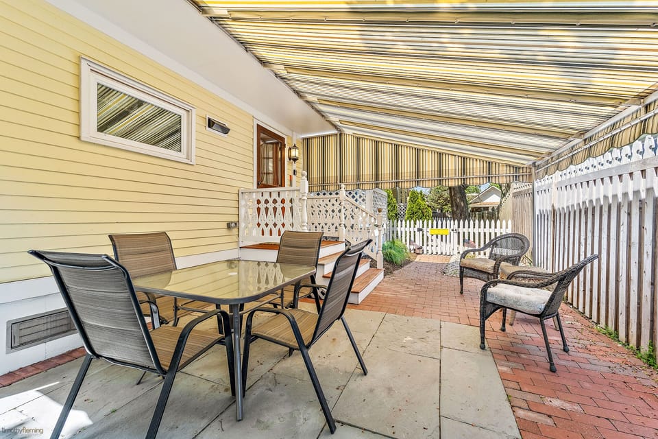 Covered porch area with seating & outdoor grill  