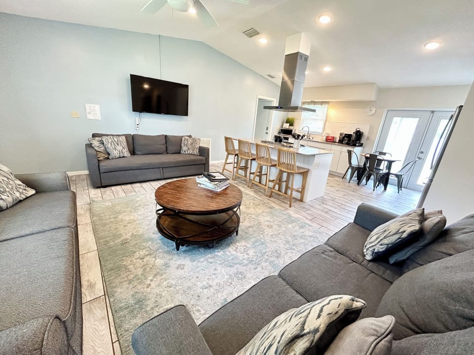Grey couch under tv and gray couch on hallway wall are queen sofa beds
