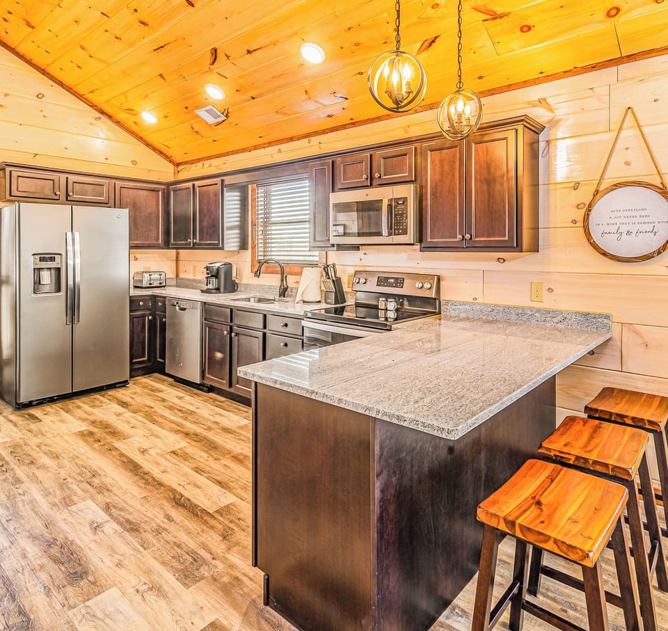 Beautiful, fully-stocked kitchen with granite countertops and peninsula seating