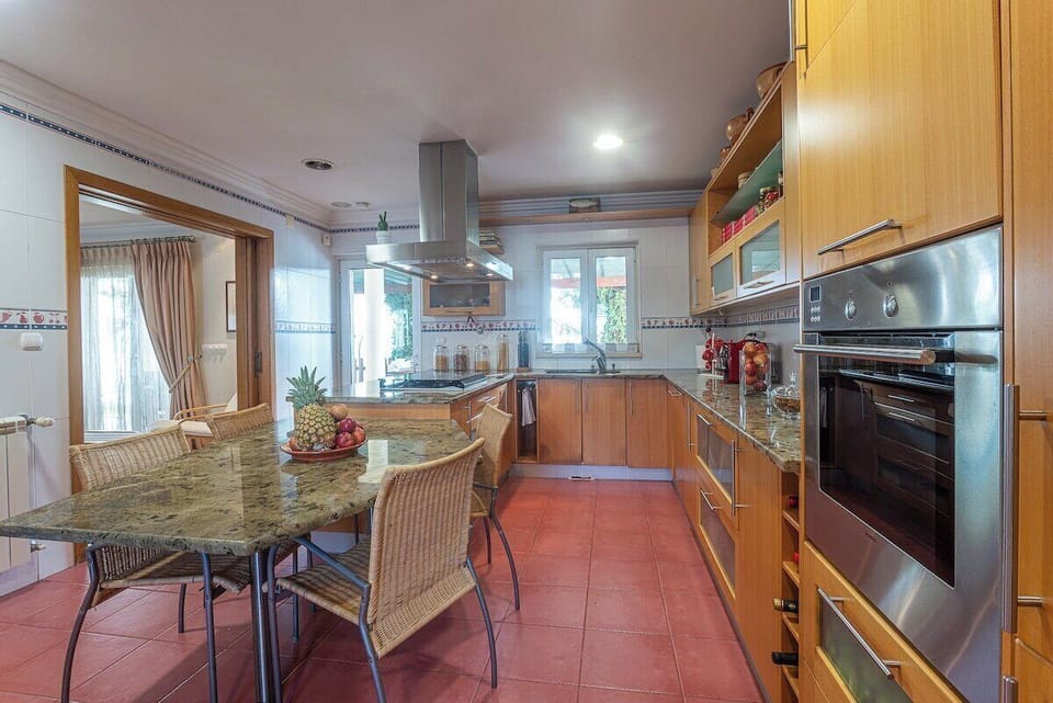 Modern kitchen with granite countertops and dining area — Villa Alegre, luxury holiday villa in Seixal